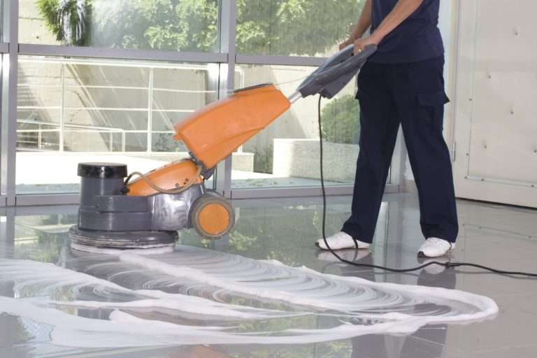 technician cleaning tile with an industrial cleaning machine