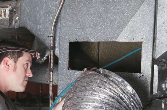 technician inspecting an air duct
